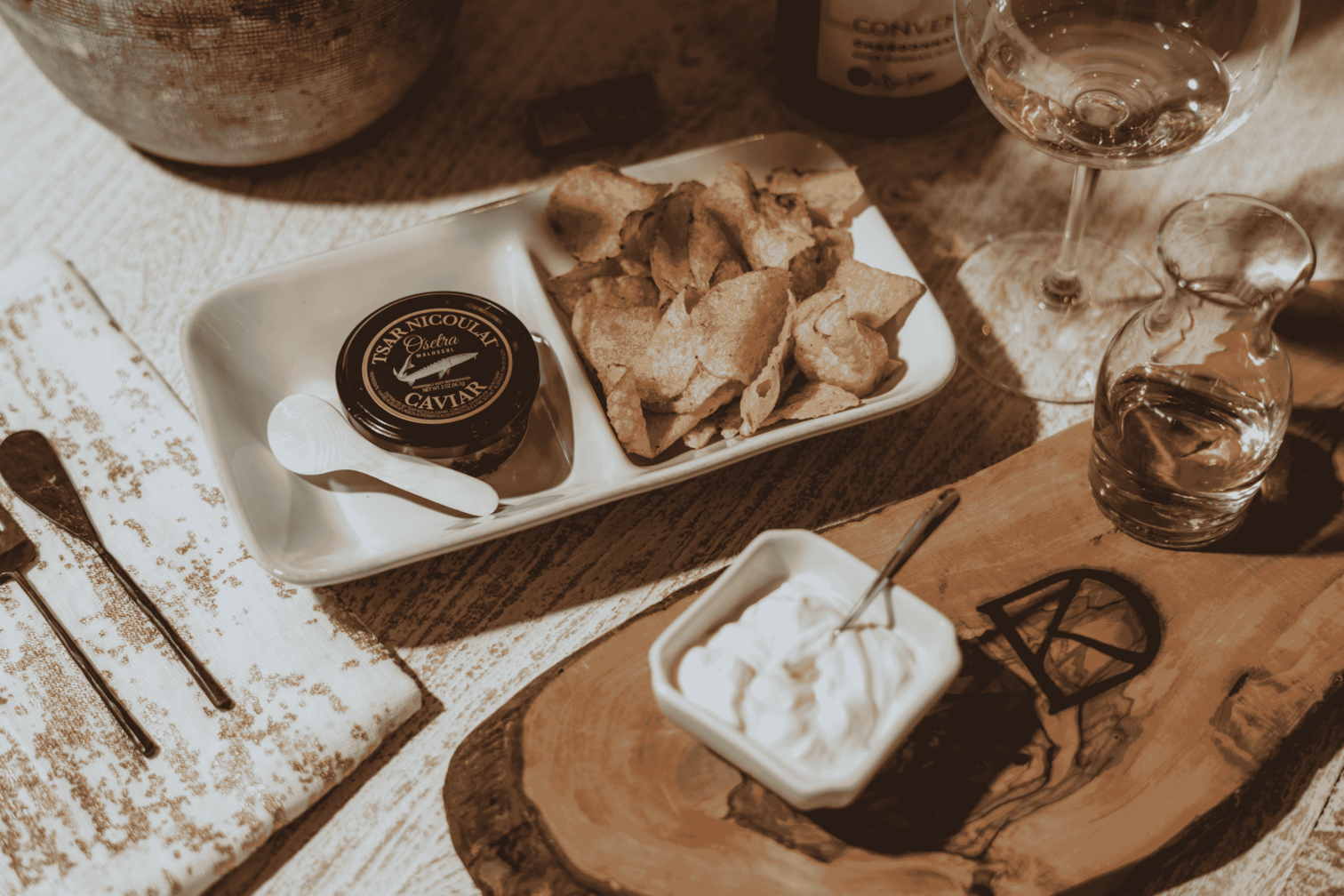 A plate of caviar, with potato chips and Convene wine.